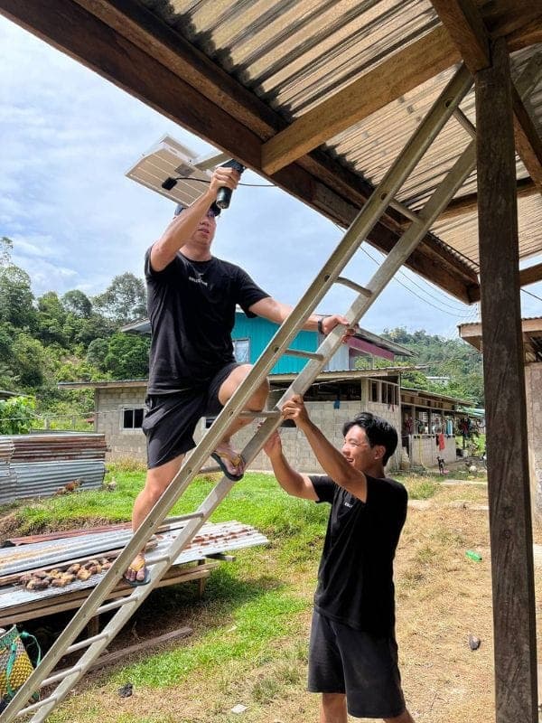 Volunteers installing lighting at a home in a rural community